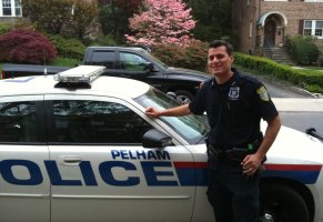 Officer Brian Hendrie in front of his police car parked at Colonial.